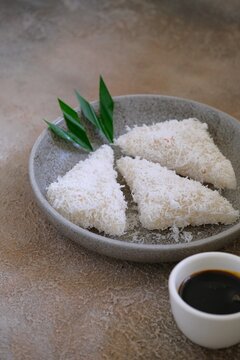 Close up Traditional Indonesian Lupis or Lopis Cake with Shredded Coconut and Palm Sugar Syrup. Made from Steamed Coconut Rice.