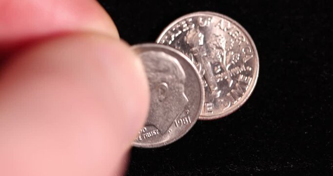 Several old worn dime coins on a black background, a group of old worn and scratched 10 cent coins in close-up on black velvet, real currency