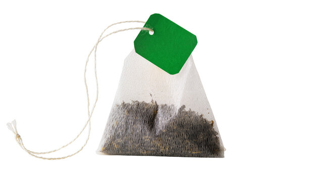 White pyramid tea bag with green tag and string, isolated on transparent background