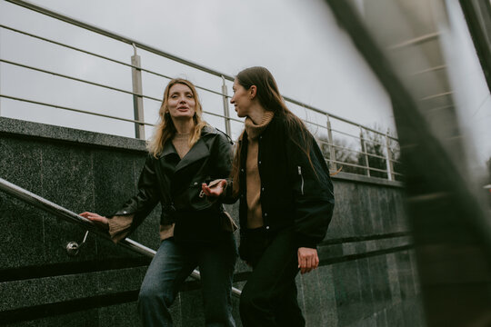 Two female friends walking outdoors on an autumn day