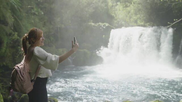 Woman Taking a Selfie in Front of a Waterfall in Southern Chile