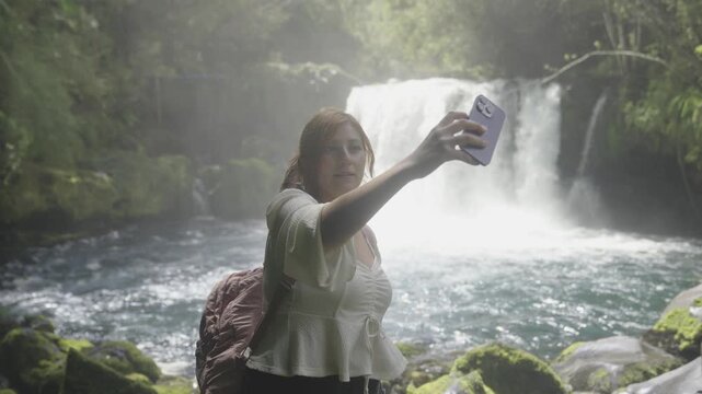 Woman Taking a Selfie in Front of a Waterfall in Southern Chile