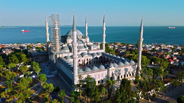 Drone view of the Blue Mosque and Sultanahmet district in Istanbul, Turkey. Sultanahmet Camii rises above trees, historic rooftops and the Bosphorus skyline.