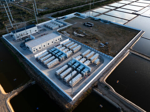 Aerial view of a large-scale energy storage power station with battery arrays and industrial facilities