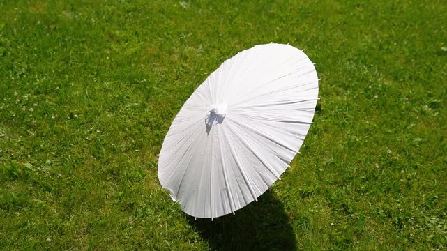 Stylish white vintage umbrellas provide shade from the hot, bright sun on a sunny summer day. Wedding ceremony for the bride and groom.