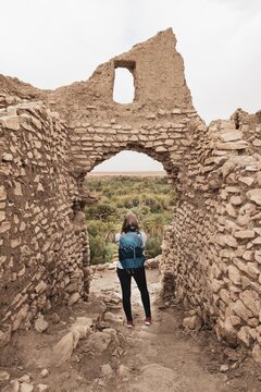 Tourist explores a ruined city, ruins, Ksar Meski, Errachidia, Morocco