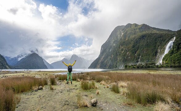 Young man jumps in the air, Mitre Peak, Bow Falls, Milford Sound, Fiordland National Park, Te Anau, Southland, South Island, New Zealand