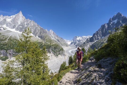 Climber on hiking trail, Grand Balcon Nord, glacier tongue Mer de Glace, behind Grandes Jorasses, Mont Blanc massif, Chamonix, France