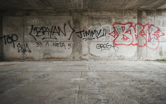 Graffiti tags and red bubble letters on a weathered concrete wall
