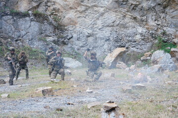 Fototapeta premium A group of soldiers in military uniforms carrying BB guns were randomly attacked and taken down during a military exercise while playing a game. 