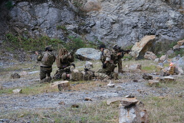 Fototapeta premium A group of soldiers in military uniforms carrying BB guns were randomly attacked and taken down during a military exercise while playing a game. 