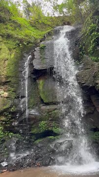 Landscape of a beautiful waterfall in a tropical forest setting.