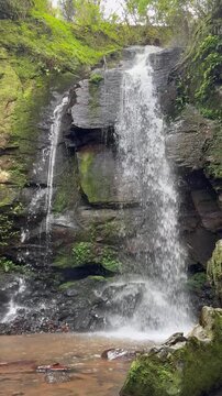 Landscape of a beautiful waterfall in a tropical forest setting.