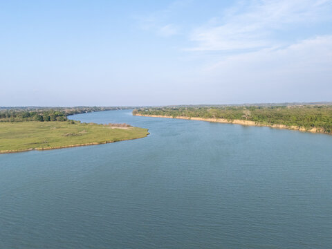 Panuco river waters flowing through a lush green landscape and fertile banks under a clear blue sky, visible from autopista tuxpan tampico, tuxpan, veracruz, mexico