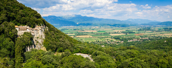 Greccio Lazio Italy 12000px drone panorama of cliffside monastery in rock with scenic mountains green fields background copy space. Authentic Borghi piu belli d Italia hidden gems High Resolution. © Freesurf