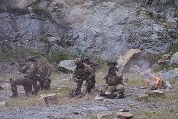 Fototapeta premium A group of soldiers in military uniforms carrying BB guns were randomly attacked and taken down during a military exercise while playing a game. 