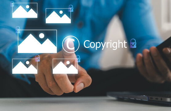 Businessman holding virtual copyright icon and photo hologram, Intellectual property protection, digital asset licensing, stock photo video rights and creative content legal ownership system
