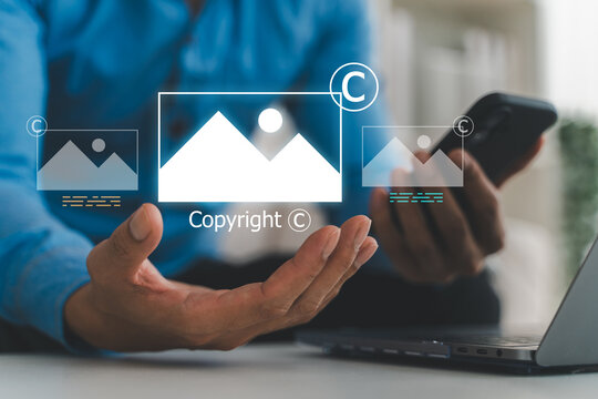 Businessman holding virtual copyright icon and photo hologram, Intellectual property protection, digital asset licensing, stock photo video rights and creative content legal ownership system
