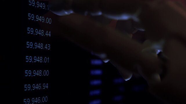 Cinematic humanoid robot hand scanning numerical spreadsheet on computer monitor close up. AI automated accounting metaphor, dark mood office, digital tech innovation, shallow DOF, natural dim light.