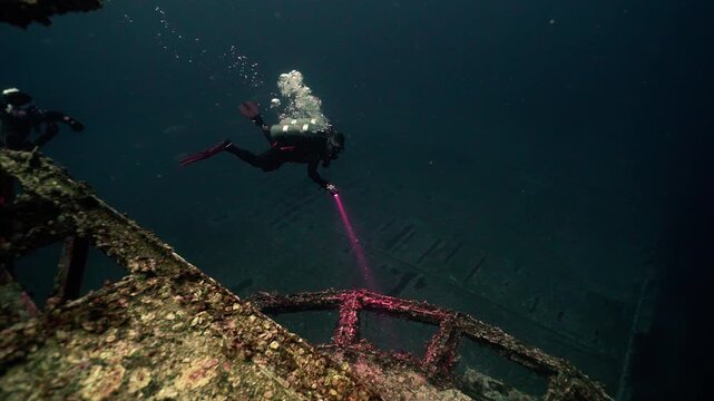 Technical Scuba Diver on Deep Dive Observing Sunken Shipwreck