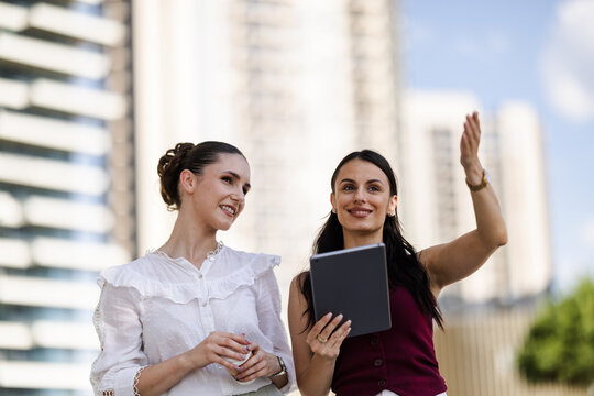 Two women discussing ideas outdoors in a modern urban setting