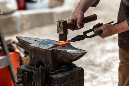Blacksmith Hammering Glowing Red Iron on Anvil