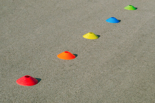Colorful Cones Placed in a Straight Line on a Sandy Surface