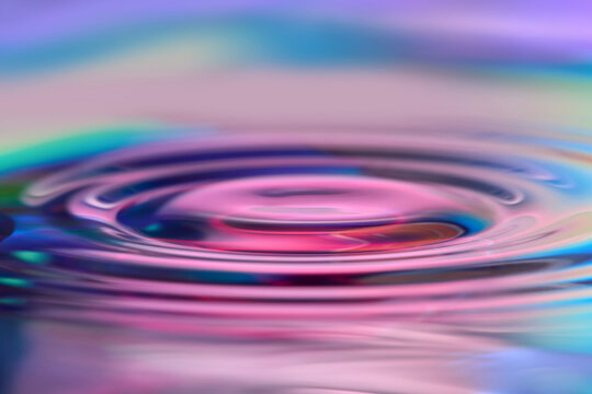 Pink purple water ripple macro on iridescent surface