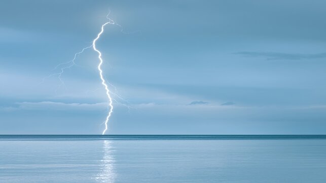 A pristine lightning bolt mirrored on a serene ocean surface at the horizon beneath a dramatic cloudy sky