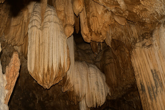 close-up view of impressive flowstone, stalactites, and limestone draperies inside khao wang thong cave, thailand, highlighting intricate speleothem formations 