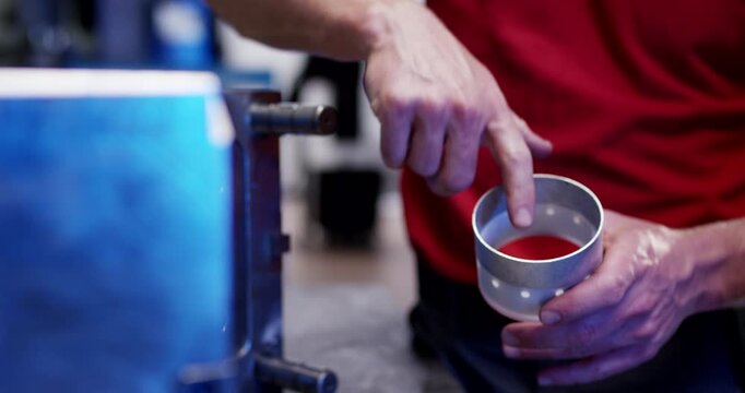 A close up view of an industrial injection molding machine opening to eject finished plastic parts