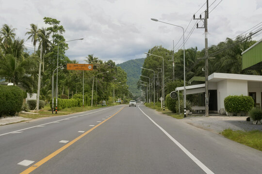highway 4014, khlong leng - khanom road, thailand, winding through tropical greenery and palm trees under a cloudy sky