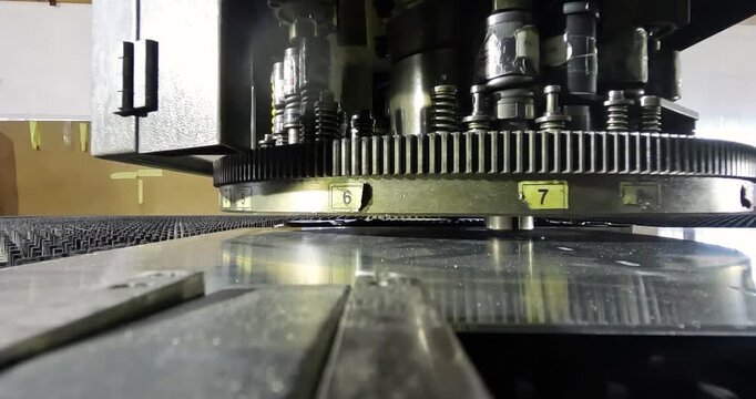 Industrial Metal Sheet Punching on CNC Machine. CNC Metal Fabrication with Turret Punch Press. Close-up of the coordinate punching machine's work table.