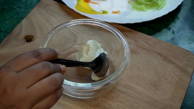 Homemade Dahi or curd or yogurt served in a glass bowl with stainless metal spoon on cutting board background. smooth creamy healthy food ingredients for eating or cooking.
