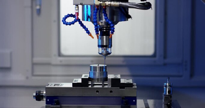 A worker placing white plastic components into a specialized machine for assembly and packaging