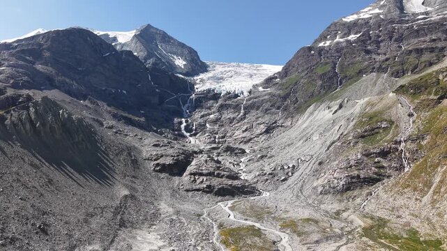 Glacier descendant d'un pic rocheux sous un ciel bleu d'&eacute;t&eacute;