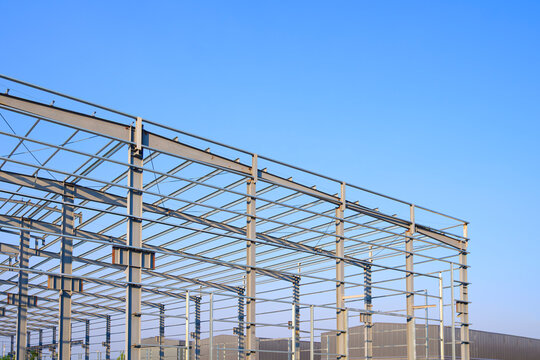 Factory warehouse industry building steel structure design, Metal framework of modern industrial buildings in construction site against blue sky background, perspective side view
