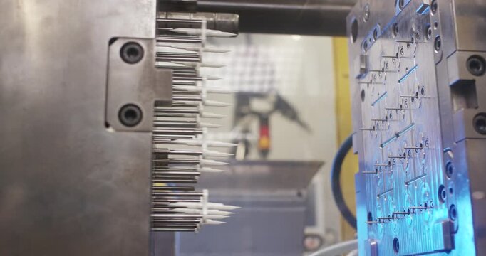 Close up of an open injection molding machine mold showing technical details in a manufacturing plant