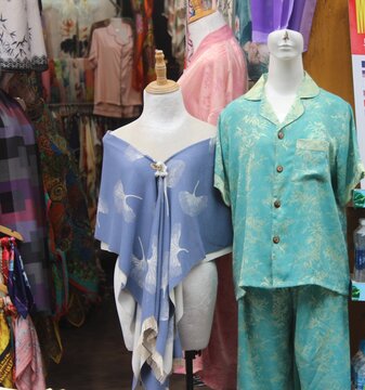 Fashion mannequins displayed in shop showing pajamas and shawl with floral prints.
