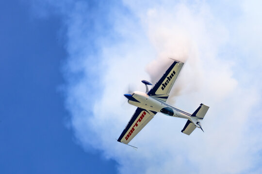 Extra 330 aerobatic aircraft cutting through smoke