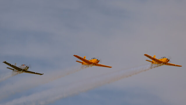 Three Beechcraft T-34 Mentor warbirds with smoke trails