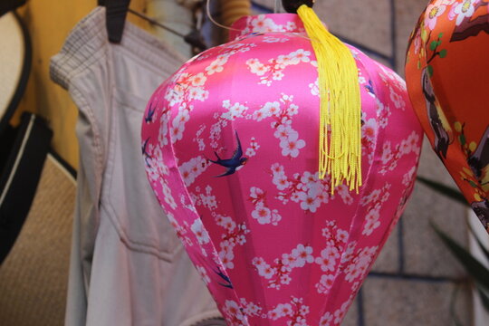 Pink fabric lantern with swallows and white cherry blossom pattern for holidays.