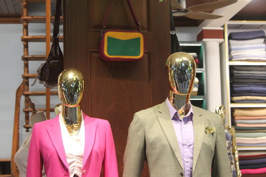 Mannequins showcasing elegant clothing inside modern luxury fashion apparel store.