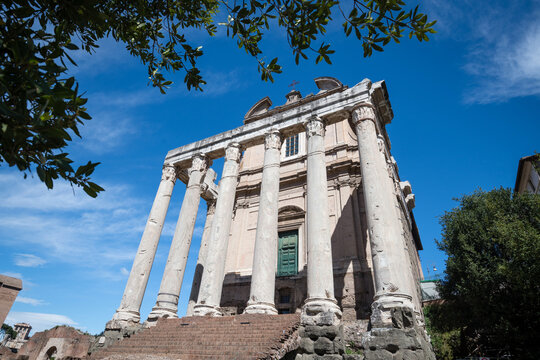 Low angle perspective of the giant ancient columns of the Temple of Antoninus and Faustina in Rome, Italy