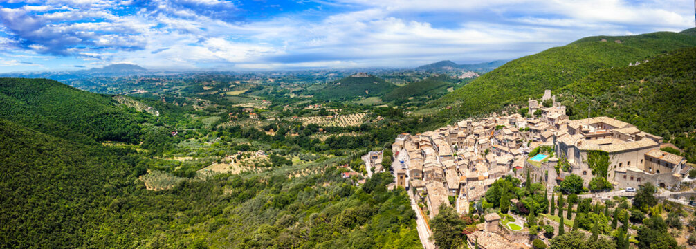 Roccantica Rieti Italy Drone panorama. Hilltop medieval borgo town with castle and swimming pool among olive trees green hills. Authentic hidden gems luxury travel asset