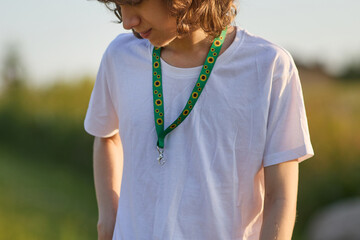 Fototapeta premium Person wearing green sunflower lanyard for hidden disability awareness