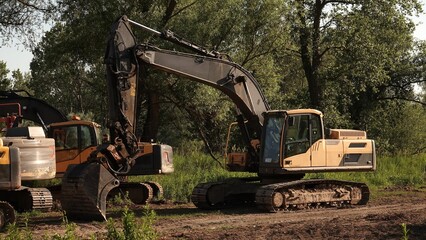 Bliskie ujęcie poziome przedstawiające kabinę operatora oraz potężną konstrukcję ramienia hydraulicznego ciężkiej koparki gąsienicowej. © tomo81