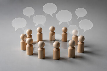 Obraz premium Wooden peg figures in a circle with speech bubbles, group communication and teamwork concept, collaborative discussion and social networking isolated on White Background ai