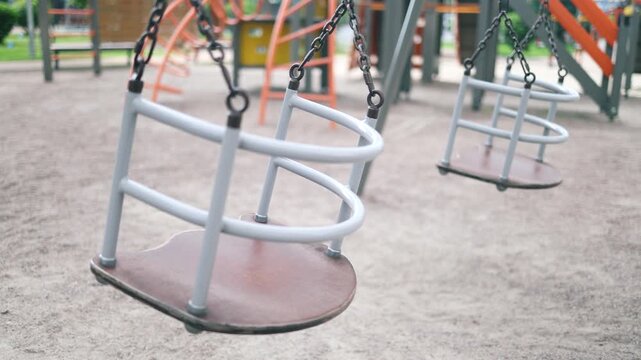 Playground in the park with hammocks swinging alone. Outdoor games for children. Hammocks, slides and colorful climbers. Nobody.
