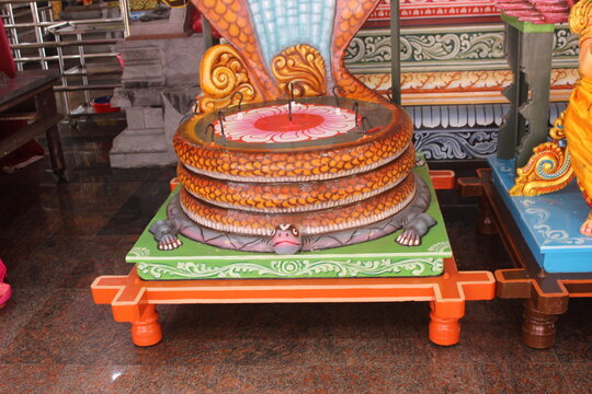 Ornate colorful religious altar base depicting a serpent and tortoise foundation.